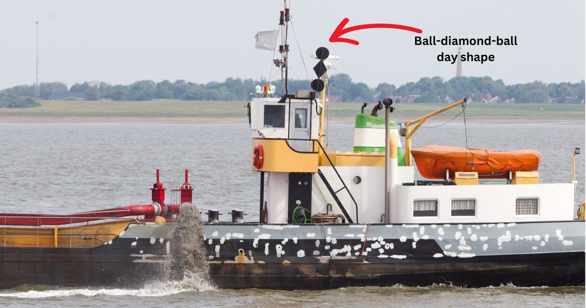 A dredger displaying a day shape of ball-diamond-ball on its mast indicating she is restricted in her ability to maneuver due to the nature of her work.