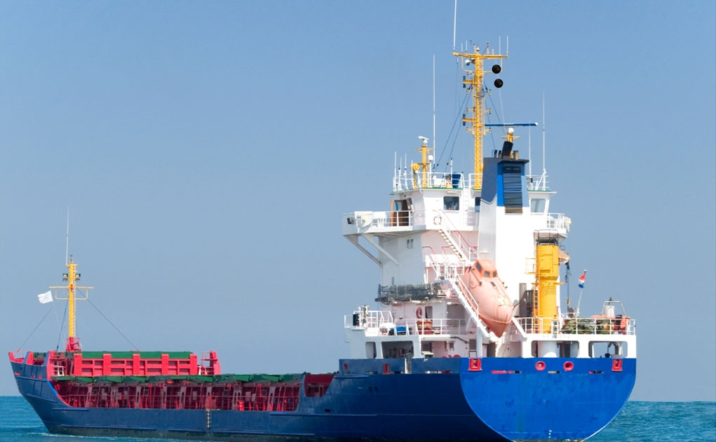 A blue cargo ship showing two black balls on its mast indicating she is not under command (NUC).